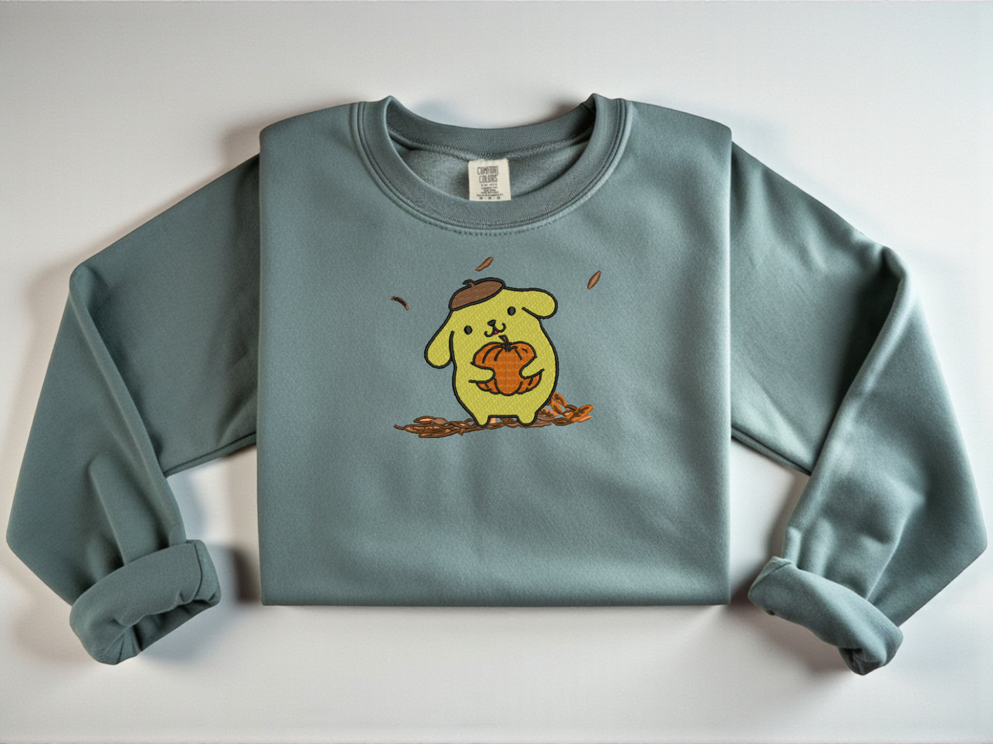 Comfort Colors Blue Spruce with an embroidered Pompompurin holding a pumpkin.