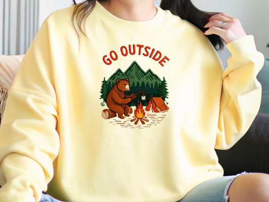 Camping bear embroidered crew neck sweatshirt featuring a bear roasting marshmallows by a campfire, cozy outdoor apparel for nature lovers.
