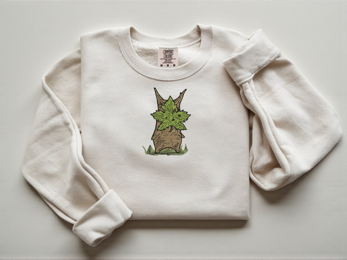 Embroidered Korok forest spirit on a white Comfort Colors 1566 sweatshirt.