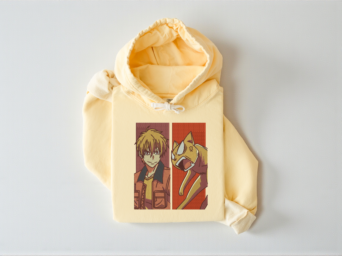 High-density embroidery featuring Kyo Sohma from Fruits Basket and his orange cat form on a Butter garment-dyed Comfort Colors 1467 hoodie.