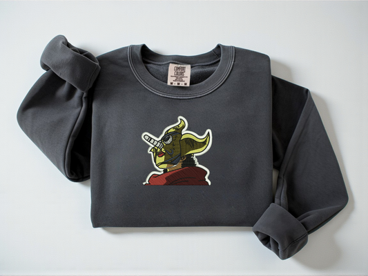 Embroidered Soge King One Piece On a Pepper Comfort Colors Crewneck with a white background.