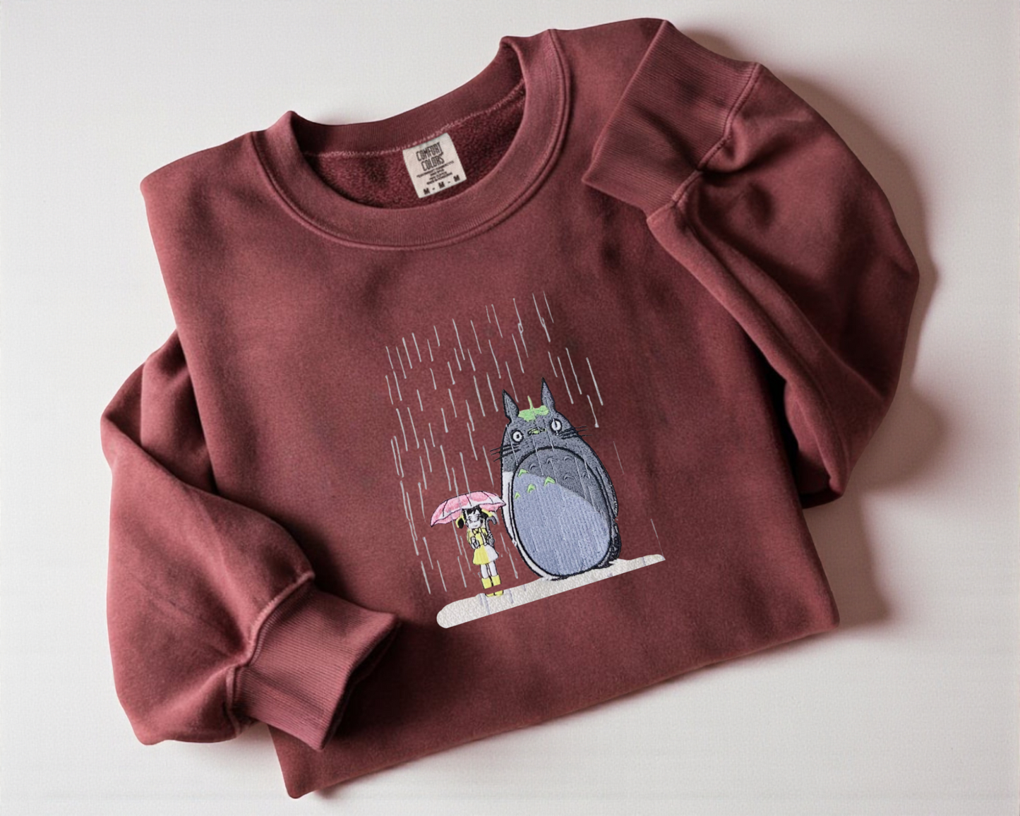 Crimson crew neck sweatshirt featuring an embroidered My Neighbor Totoro design, cute Japanese anime apparel for Ghibli fans.