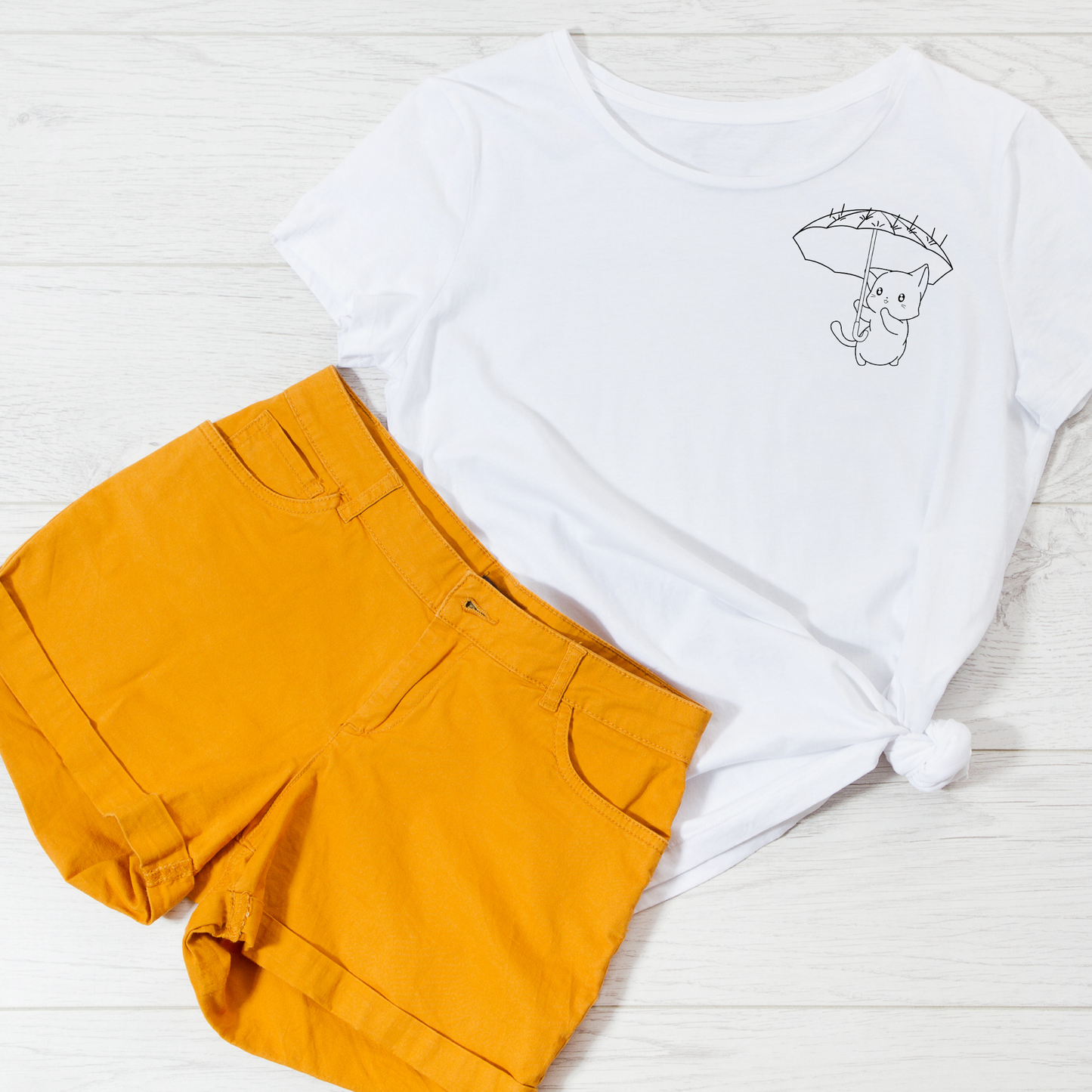 A T-Shirt with a cat holding an umbrella with orange shorts