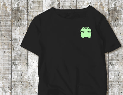 A Green Frog holding his face up on a Black-Tshirt