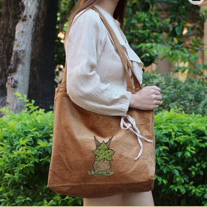 A woman carrying a Brown Zelda embroidered Tote bag 