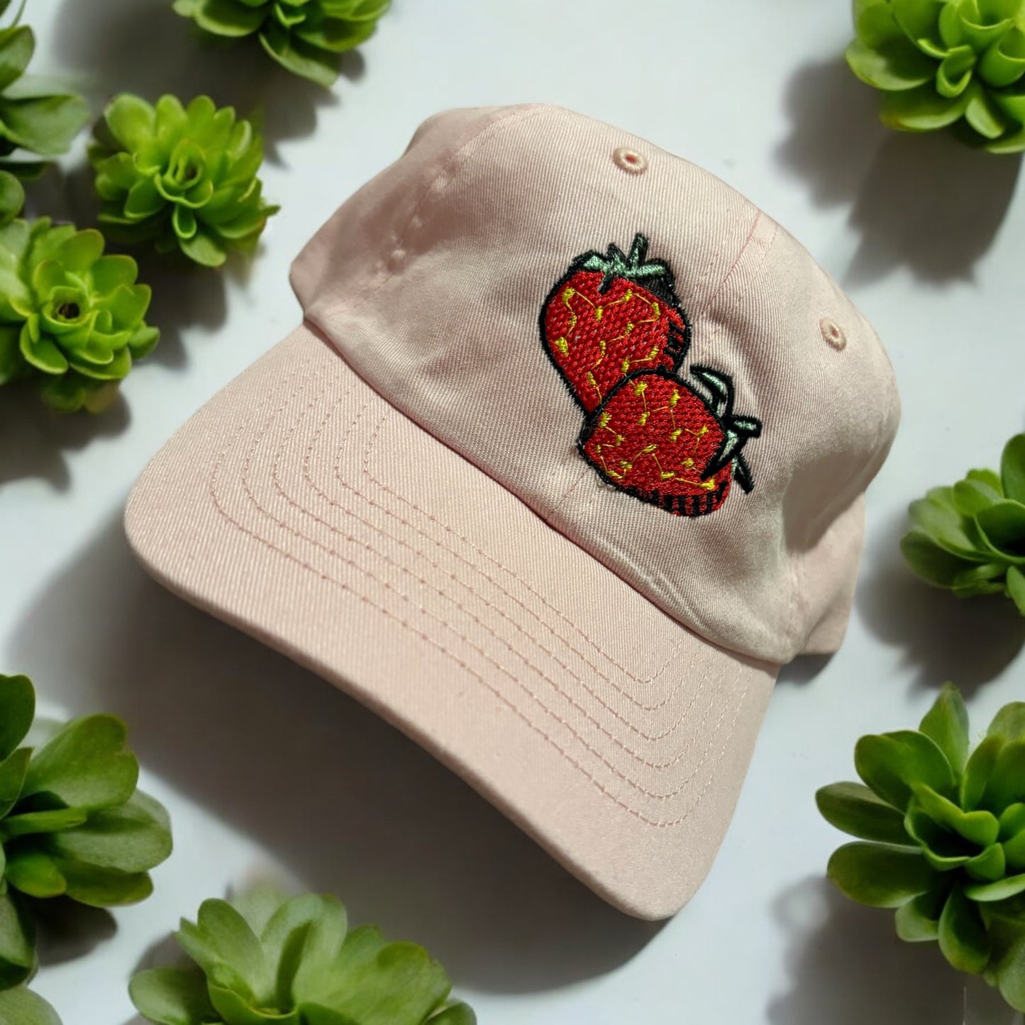 An Embroidered hat with a strawberry design