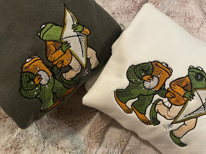 Comfort Colors 1566 sweatshirts featuring detailed embroidery of Frog and Toad with a kite. Vintage bookish aesthetic crewneck.