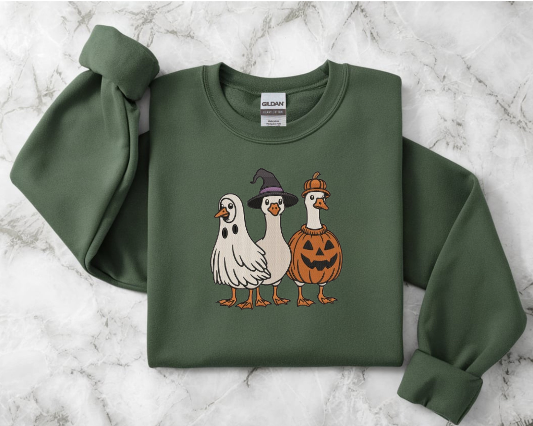 Green sweatshirt with Halloween-themed duck illustrations 