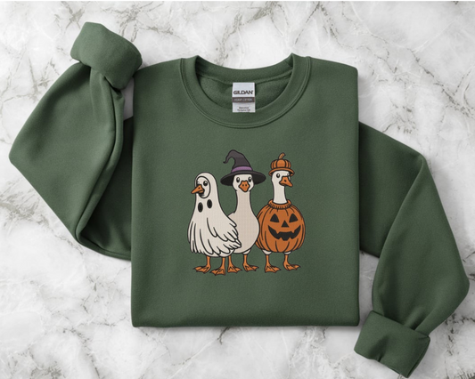 Green sweatshirt with Halloween-themed duck illustrations 
