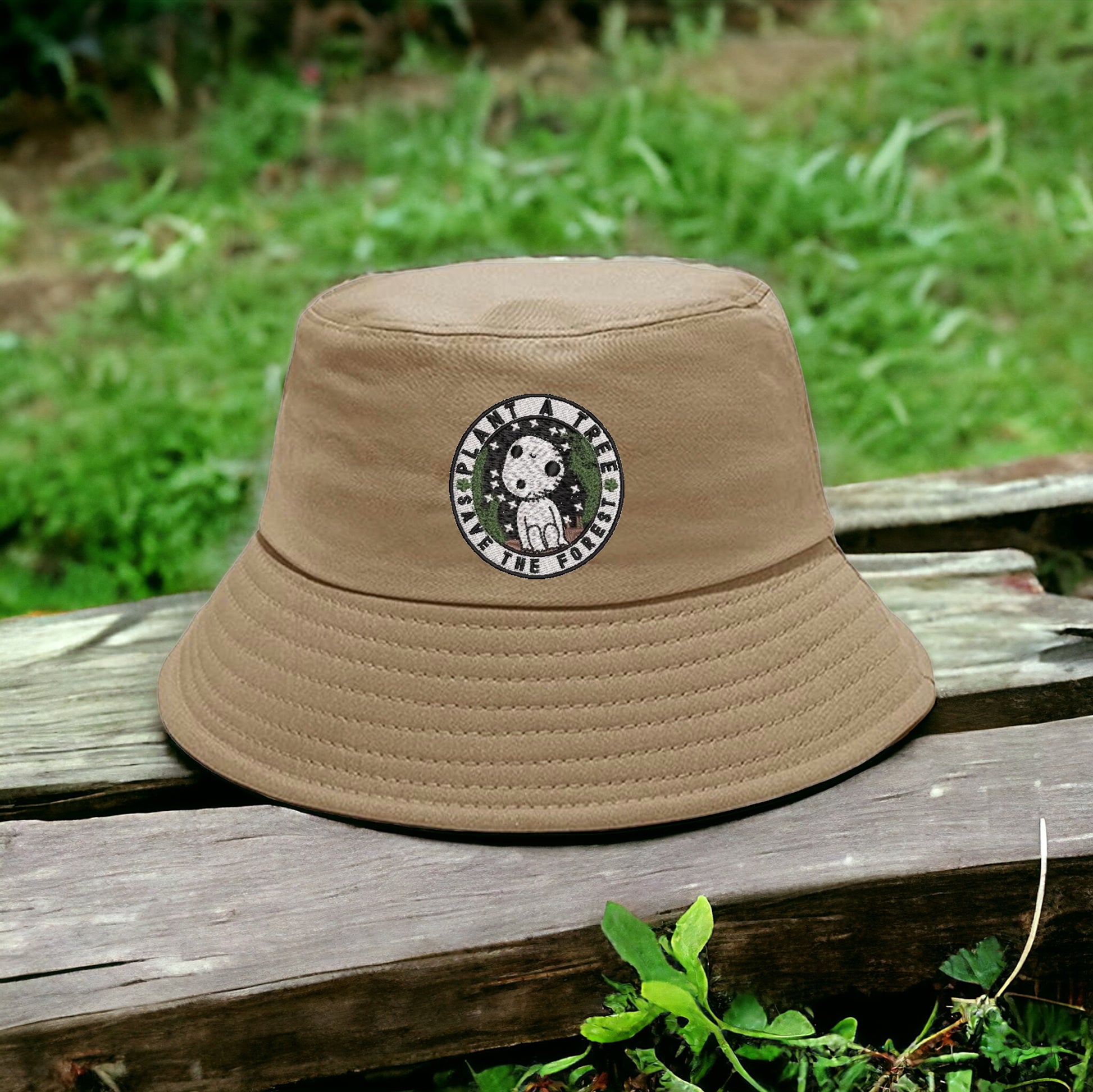 A beige bucket hat with a white embroidered design featuring Kuroma