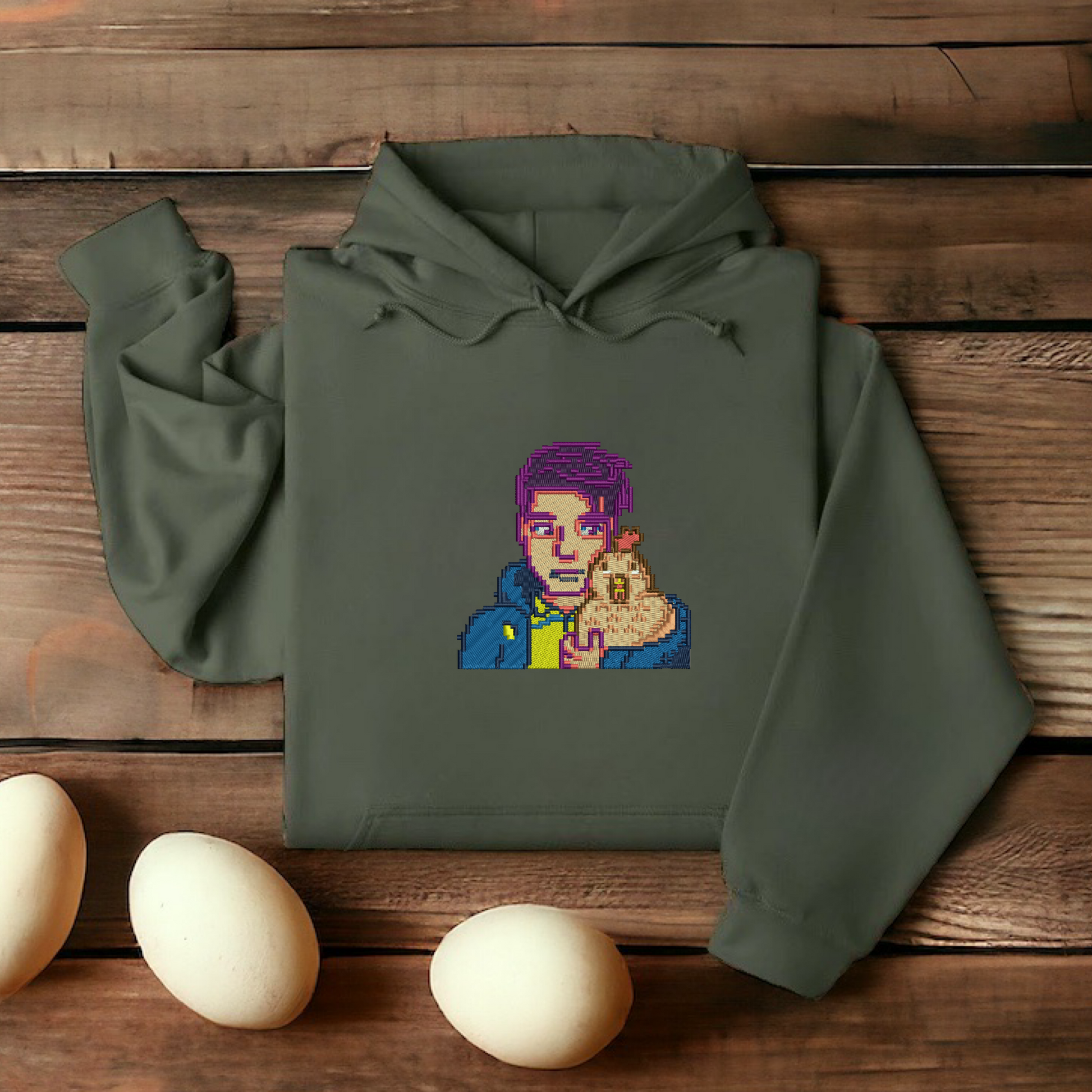 Embroidered Green hoodie featuring Shane and his chicken from Stardew Valley, designed for cozy comfort and perfect for fans of the game.