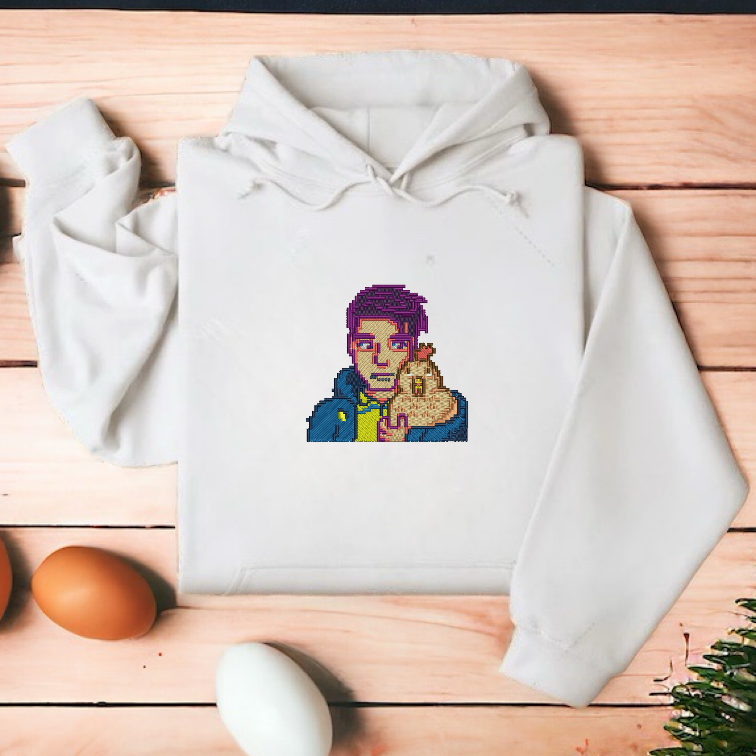 Embroidered White hoodie featuring Shane and his chicken from Stardew Valley, designed for cozy comfort and perfect for fans of the game.