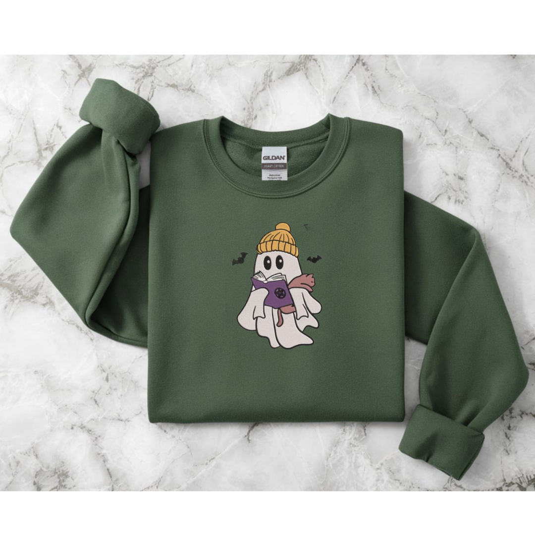 Green sweatshirt with a ghost wearing a yellow beanie design on a marble surface
