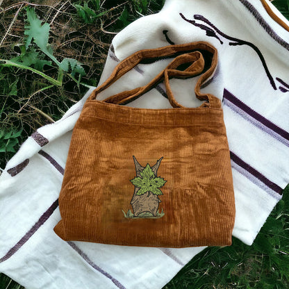 A Brown Embroidered Tote Bag that has a character from Zelda named Korok