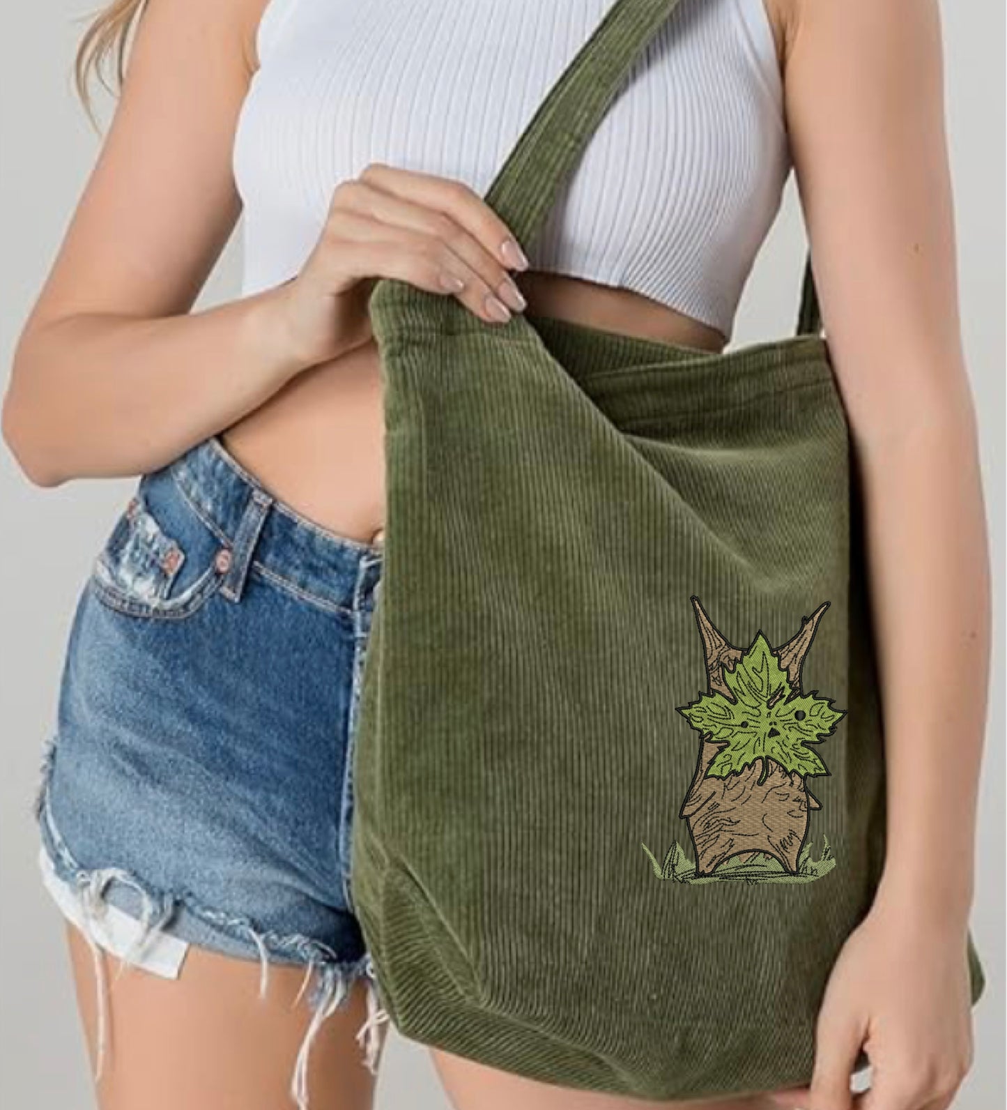 A Woman carrying a Zelda Korok Green Embroidered Tote Bag 