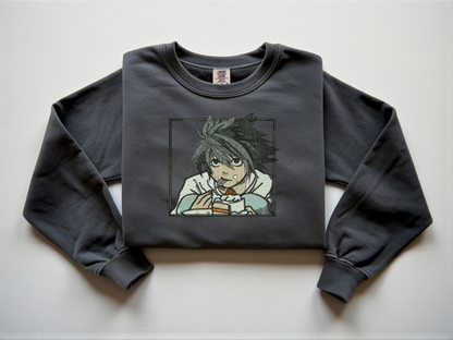 Pepper Comfort Colors crewneck sweatshirt with minimalist black line embroidery of L from Death Note crouching eating cake.