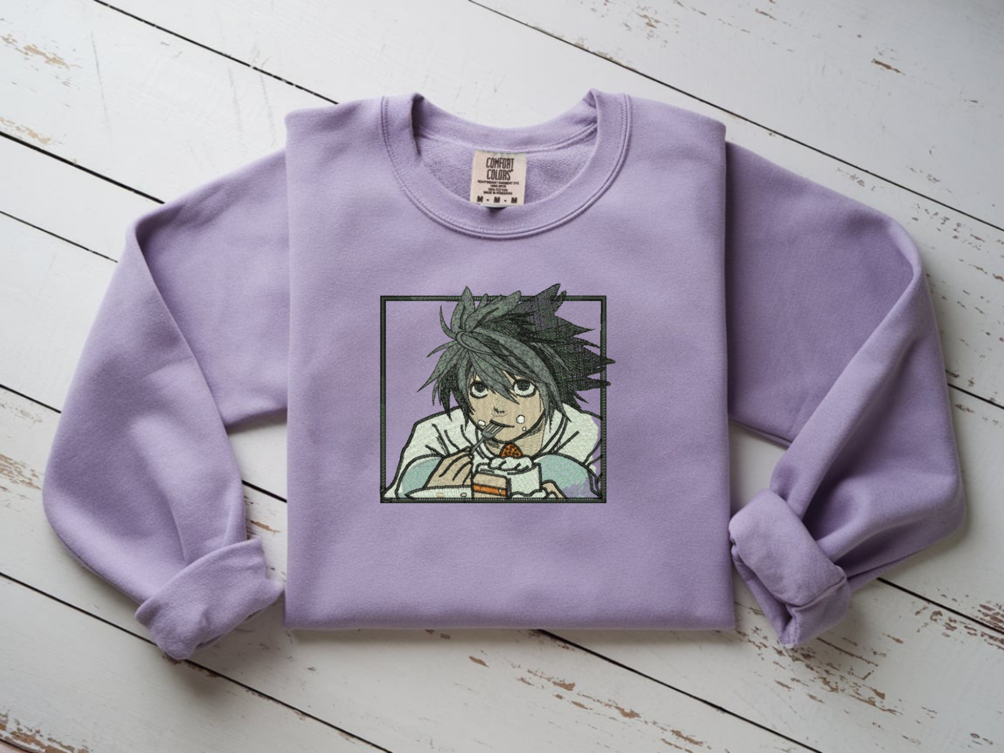 Orchid Comfort Colors crewneck sweatshirt with minimalist black line embroidery of L from Death Note crouching eating cake.