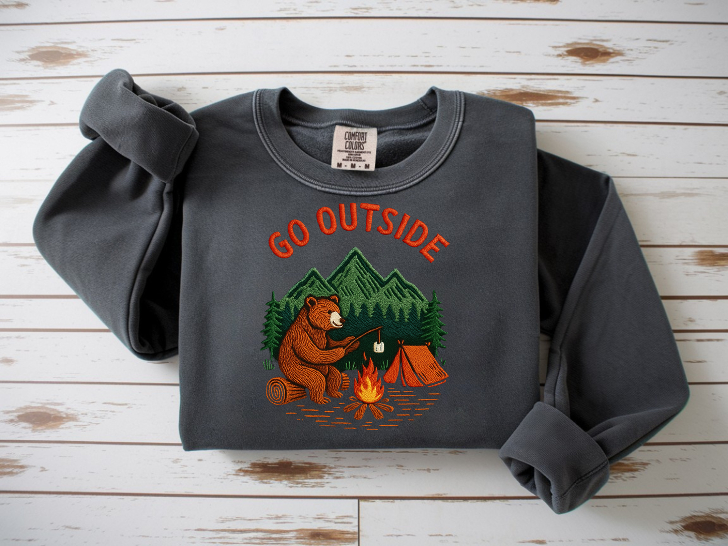Camping bear embroidered pepper crew neck sweatshirt featuring a bear roasting marshmallows by a campfire, cozy outdoor apparel for nature lovers.