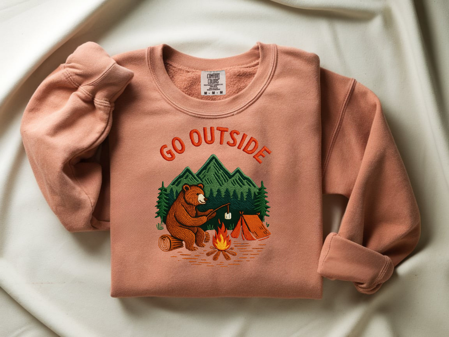 Camping bear embroidered terracotta crew neck sweatshirt featuring a bear roasting marshmallows by a campfire, cozy outdoor apparel for nature lovers.