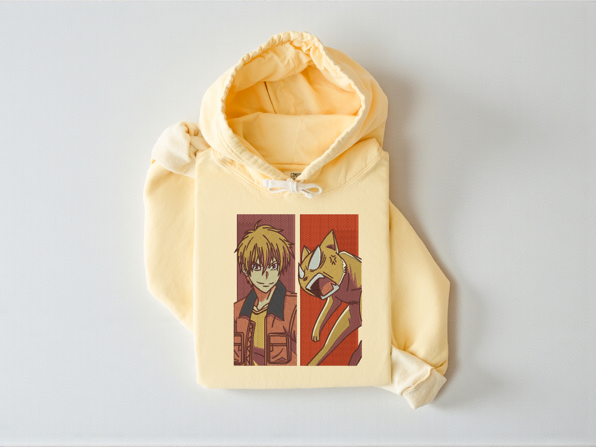High-density embroidery featuring Kyo Sohma from Fruits Basket and his orange cat form on a Butter garment-dyed Comfort Colors 1467 hoodie.