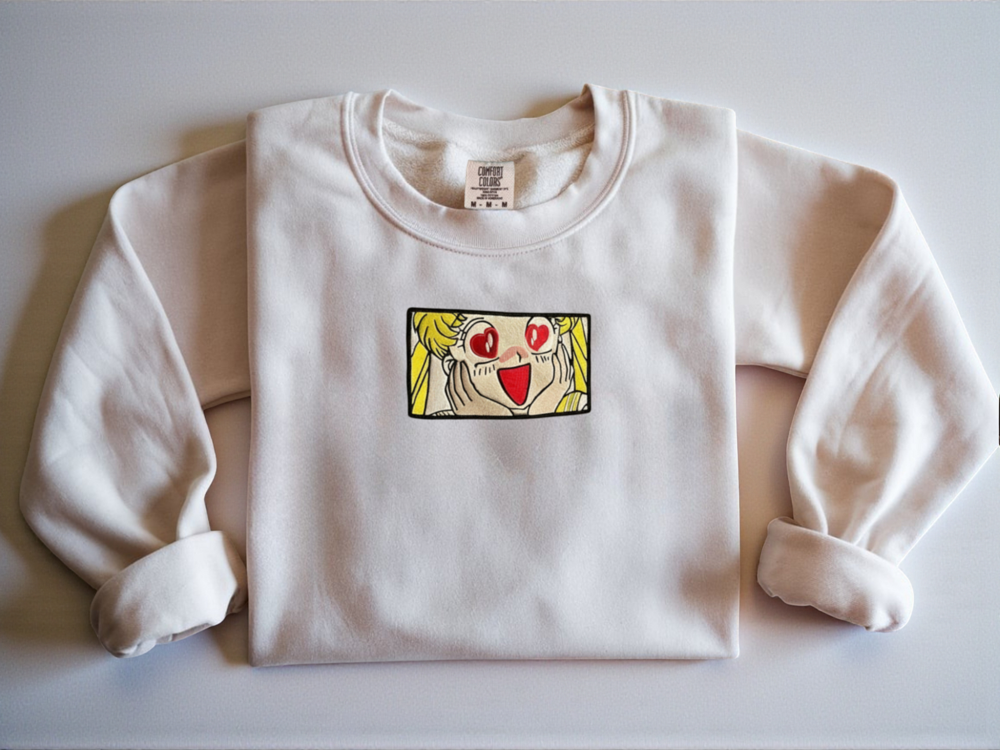 White Comfort Colors Crewneck with a Sailor Moon Venus embroidered design with heart eyes.